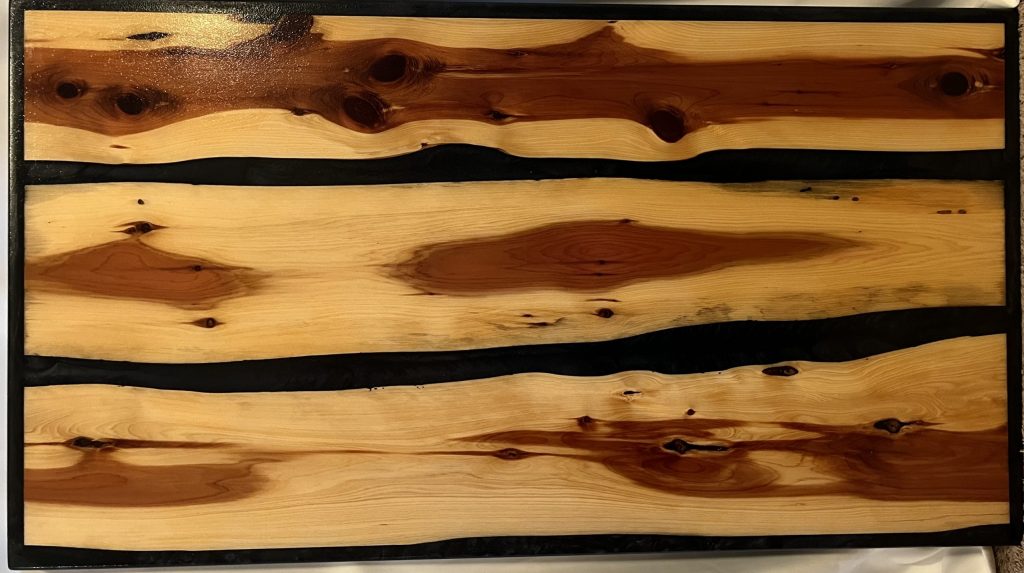 Red cedar Coffee Table with Black river feature and border. ~44″x24″ Signature epoxy finish