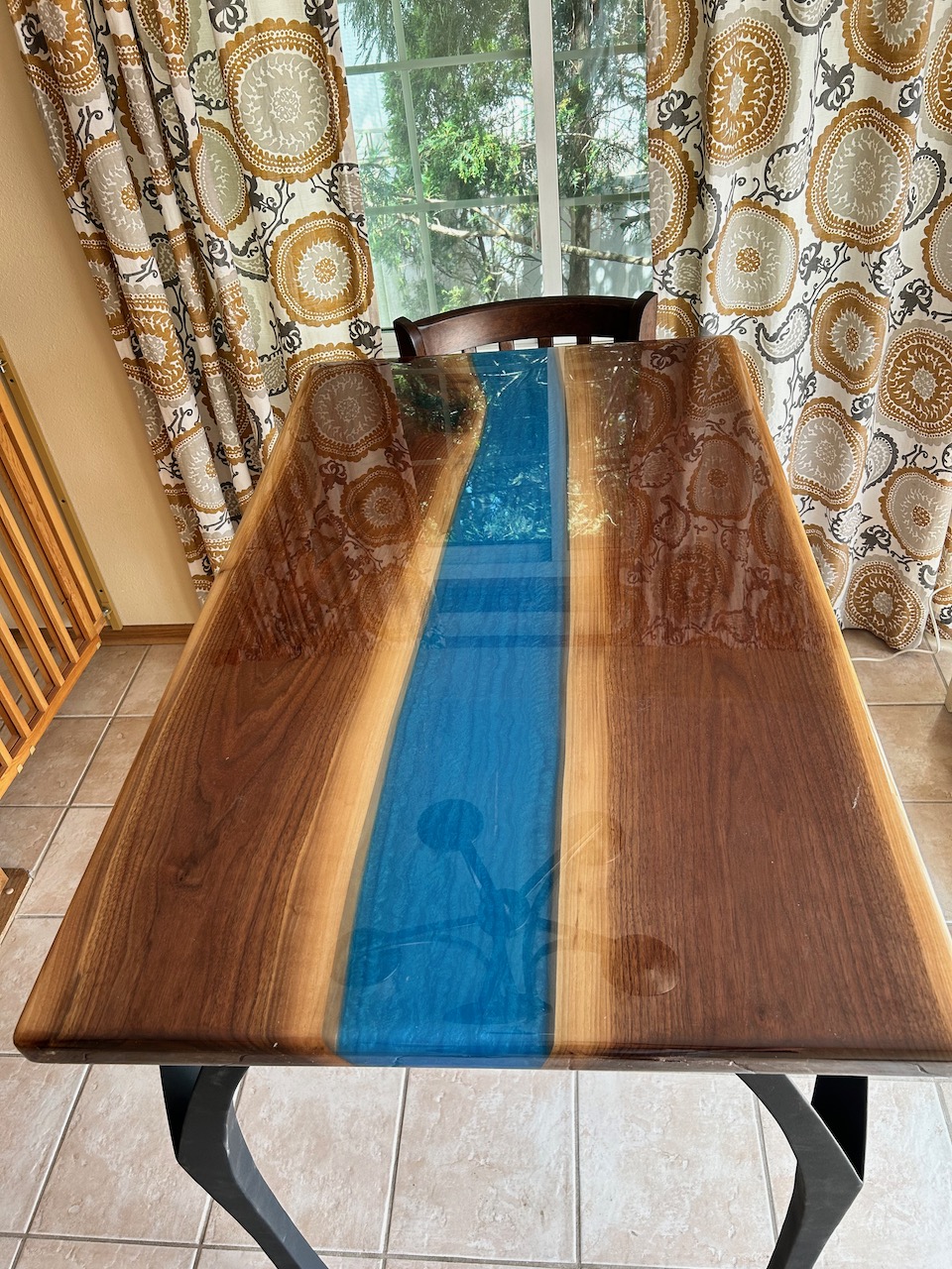 Black Walnut Breakfast Table with Blue river. 48×29 Epoxy Clear coat finish. Custom tall legs for bar-stool seating.